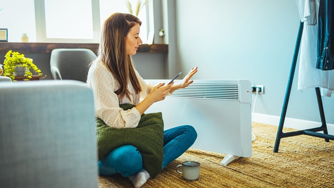 woman sitting in front of a heater